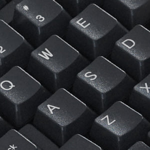 Nahaufnahme schwarzer Computertastaturtasten mit QWERTY-Layout mit weißer Schrift. Zu den sichtbaren Tasten gehören Q, W, E, A, S, D und Z.